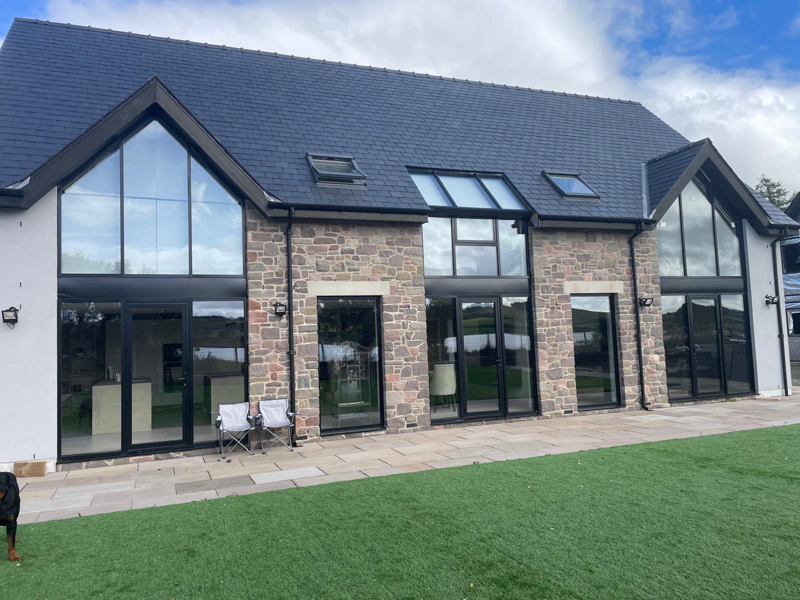 Aluminium gable windows and garden-facing doors in a brick home